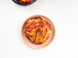 Vegan nectarine peach cake on white table, summer fruit pie