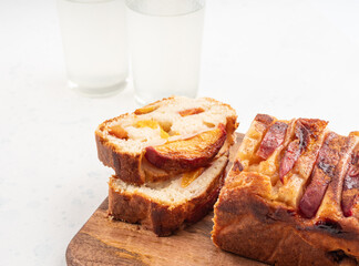 Peach cake loaf on wooden cutting board on white backgroud