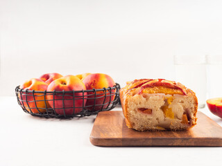 Peach cake loaf on wooden cutting board on white backgroud