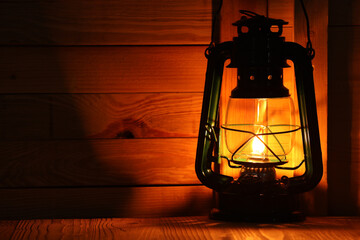 Vintage kerosene lamp on wooden table. Space for text