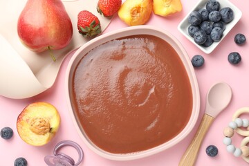 Baby food. Tasty puree in bowl, spoon and ingredients on pink table, flat lay