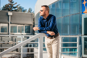 Man in sunglasses enjoys sunny day on outdoor balcony