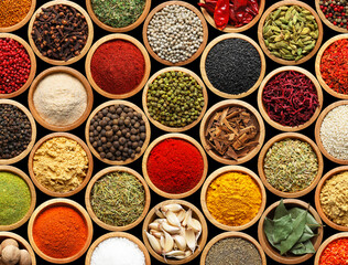 Set of different aromatic spices in bowls on black background, flat lay