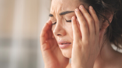 Fototapeta premium Young woman with headache in home