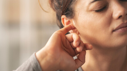 Woman investigating the contents of his ear with her finger
