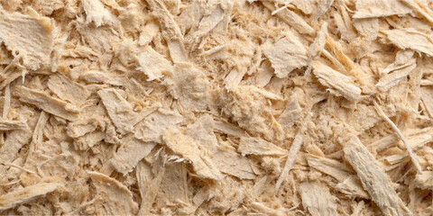 Light-colored wood shavings cover the surface in a workshop. The shavings appear fine and are likely remnants from woodworking projects that occurred recently