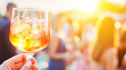 Refreshing cocktail at outdoor summer party with blurred background