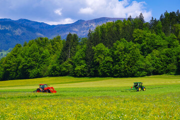 Scene of a tractor on a lawn in front of the Julian Alps, Kamnic, Slovenia, Europe