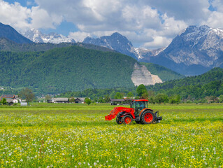 Scene of a tractor on a lawn in front of the Julian Alps, Kamnic, Slovenia, Europe