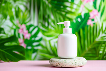 Stylish ceramic soap dispenser on stone base with tropical leaf background