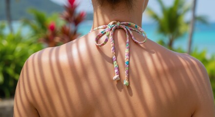 Back with palm leaf shadows and bikini ties creating striped pattern on skin. Artistic portrait. Summer and tropical vacation concept. Image for poster, wallpaper, banner and fashion
