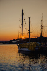 Oslo harbour with Stiftelsen Christian Radich and Skur 32 at dusk transforms into a mesmerising scene, with long-exposure capturing the vibrant night lights reflecting on the calm water