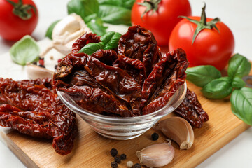 Delicious sun dried tomatoes, fresh vegetables and spices on table, closeup