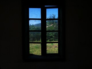 Old wooden dirty window. View through dirty glass on window