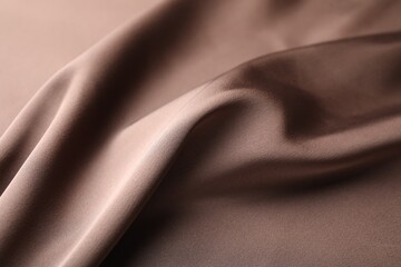 Fototapeta premium Crumpled light brown silk fabric as background, closeup