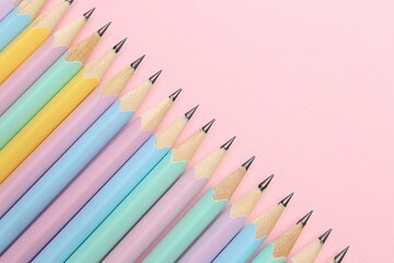 Many graphite pencils on pink background, flat lay. Space for text