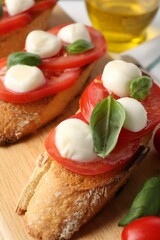 Tasty sandwiches with mozzarella cheese, tomatoes and basil on table, closeup