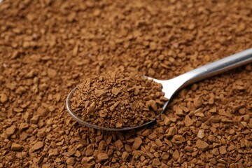 Spoon on aromatic granulated instant coffee, closeup view