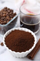 Instant coffee powder in bowl, beans and drink on white table, closeup
