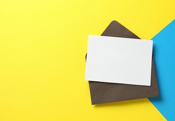 Blank invitation card and envelope on color background, top view. Space for design