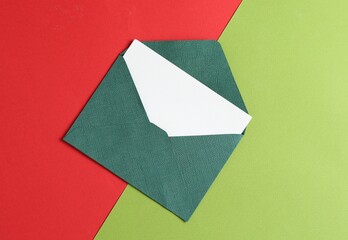 Blank invitation card and envelope on color background, top view