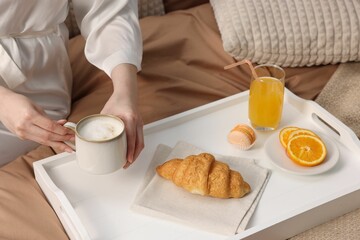 Woman having delicious breakfast in bed, closeup