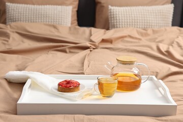 Tray with delicious breakfast on bed indoors, closeup. Space for text