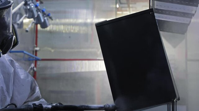 Powder coating application on metal panel, spray gun disperses even layer, Industrial painting process for corrosion protection and aesthetic durability