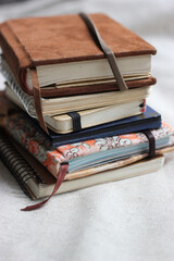 A stack of different notebooks close up. Colorful Notebook Covers. Artist's Notebook Collection....