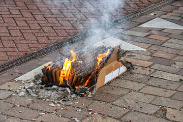 box of burnt out fireworks is outside on the street