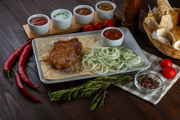 Shashlik with sauces and fresh bread on wooden background