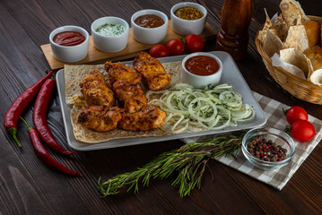 Shashlik with sauces and fresh bread on wooden background