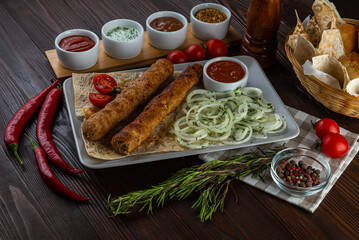 Beef kebab with sauces on wooden background