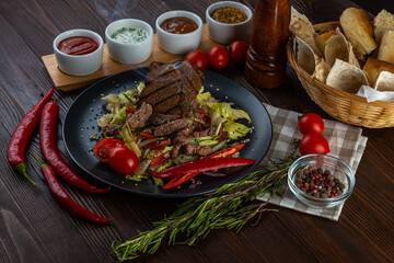 Spicy salad with beef on wooden background