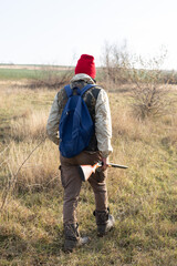 Mature hunter man holding a shotgun and walking through a field