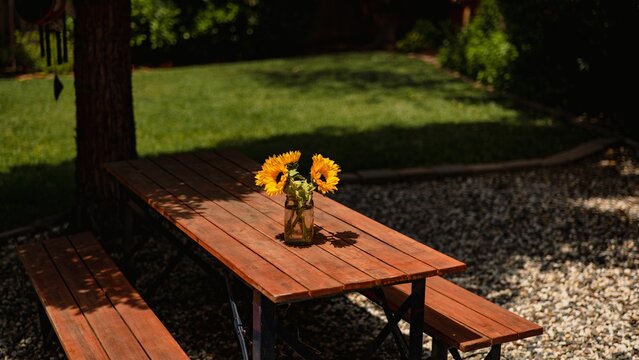 Picnic Table with Sunflowers in Backyard