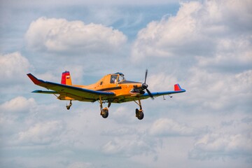 Yellow agricultural plane flies in the sky. small aviation, light aircraft