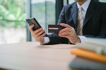 Man using paying through credit card while online shopping on laptop in office