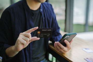 Online shopping. Man hand holding credit card and using laptop at office, Businessman or entrepreneur working , e-commerce, internet banking, spending money, working from home concept