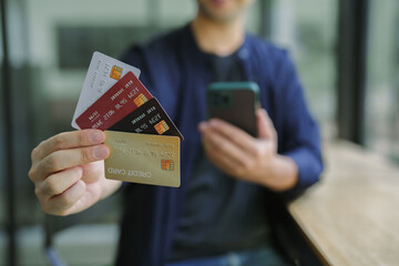 Online shopping. Man hand holding credit card and using laptop at office, Businessman or entrepreneur working , e-commerce, internet banking, spending money, working from home concept
