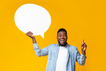 I have an idea. Inspired african american man holding empty speech bubble on yellow studio...