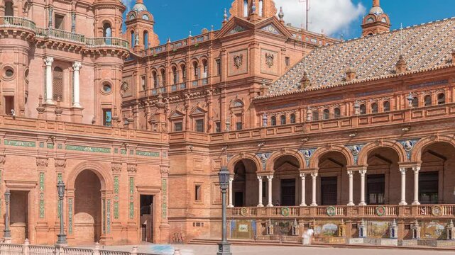 Plaza de Espana in Seville timelapse, a grand architectural complex in Maria Luisa Park built for the Ibero-American Exposition. Arches, canal and red walls under blue cloudy sky.