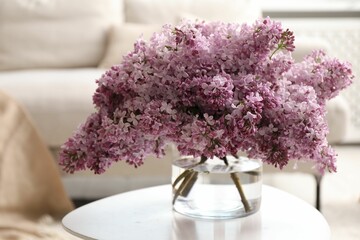 Beautiful lilac flowers in vase on table indoors