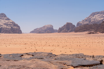 Fototapeta premium Majestic Desert Landscape: Witness the raw beauty of a vast desert landscape, with rugged rock formations and a boundless sky, evoking a sense of awe and timelessness.