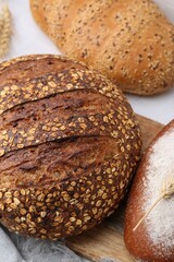 Fresh bread loaves on white table, flat lay