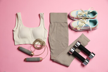Sportswear and different gym accessories on pink background, flat lay