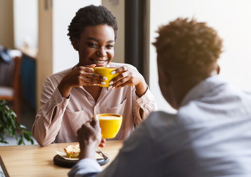 Happy African American couple on their first date in cafe, talking and enjoying each other