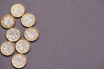 one pound notes arranged neatly on a gray background.