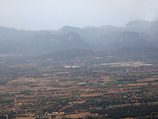 Aerial view of Mallorca lands, Sencelles fincas and Biniali village homes, Binissalem town and insustrial state, Consell municipality plots, Alaró and Serra de Tramuntana mountains in background. 