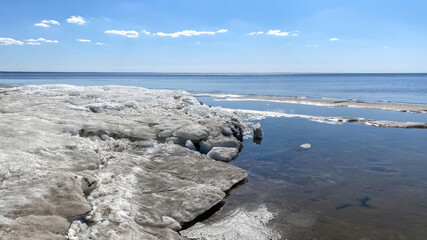 Blocks of melting ice on the shore of a vast lake during the spring thaw, Parnu, Estonia